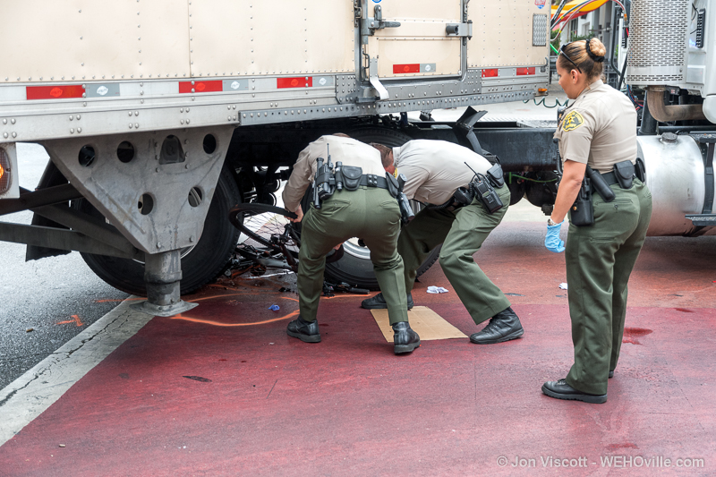 Deputies remove bicycle from under truck. (Photo by Jon Viscott)