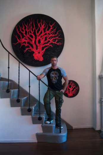 Carl Hopgood in the middle of "Coral of Medusa" 2016, acrylic on canvas, ruby red and black glitter 60" diameter and "Coral of Medusa" 2016, 15" diameter. (Photo by William Callan).